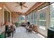 Light-filled sunroom featuring tile floors, stylish furnishings, and tranquil outdoor views at 13170 Se 92Nd Court Rd, Summerfield, FL 34491