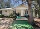 Quaint single-story home featuring a covered porch, natural landscaping, and mature shade trees at 15536 Se 203Rd Ave, Umatilla, FL 32784