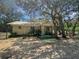 Exterior view of cozy single-story home featuring a covered porch and spacious yard with mature trees at 15536 Se 203Rd Ave, Umatilla, FL 32784