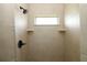 Tile shower with a black shower head and faucet and a small window for natural light at 1829 Nw 85Th Loop, Ocala, FL 34475