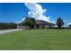A single-story home with a lush green lawn, complemented by mature trees and a long driveway at 1829 Nw 85Th Loop, Ocala, FL 34475