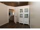 Hallway with wood floors leading to living area and white cabinet at 1829 Nw 85Th Loop, Ocala, FL 34475