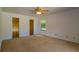 Bright bedroom with neutral carpet, a ceiling fan, closet, and ample natural light at 205 Ne 53Rd St, Ocala, FL 34479