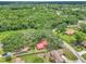 An aerial view captures a charming home with a red roof, surrounded by lush greenery, offering privacy and serenity at 2676 Se 52Nd Ave, Ocala, FL 34480