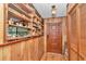 Welcoming entryway with hardwood floors, wooden paneled walls, and custom-built shelving for showcasing décor at 2676 Se 52Nd Ave, Ocala, FL 34480