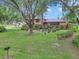 Home featuring a red roof, manicured front yard, and mature trees creating a welcoming entrance at 2676 Se 52Nd Ave, Ocala, FL 34480