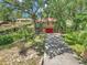 Home's front yard with lush greenery, long driveway, and colorful landscaping at 2676 Se 52Nd Ave, Ocala, FL 34480