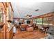 Spacious living room features a brick fireplace, wood paneled accent walls, and large windows at 2676 Se 52Nd Ave, Ocala, FL 34480