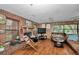Cozy living room with a brick fireplace, wood paneled accent walls and hardwood flooring at 2676 Se 52Nd Ave, Ocala, FL 34480