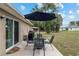 Backyard patio with a table and chairs, a large umbrella, and a grill at 2690 Sw 154Th Ln, Ocala, FL 34473