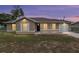 Charming single-story home featuring a covered porch, manicured lawn, and neutral exterior paint under a twilight sky at 2690 Sw 154Th Ln, Ocala, FL 34473