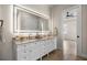 Luxurious bathroom features a dual vanity, marble countertop, and a large, lighted mirror at 2792 Se 29Th St, Ocala, FL 34471