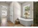 Bright bathroom features a freestanding tub with brass hardware and a large window at 2792 Se 29Th St, Ocala, FL 34471