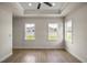 Bedroom featuring tray ceilings, light wood flooring, and large windows providing natural light at 2792 Se 29Th St, Ocala, FL 34471