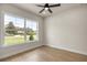 Bedroom with light-colored walls, wood-look flooring, a ceiling fan, and a large window with neighborhood views at 2792 Se 29Th St, Ocala, FL 34471
