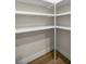 Simple walk-in closet featuring built-in shelving and wood-look tile flooring at 2792 Se 29Th St, Ocala, FL 34471