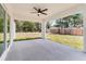 Open-air back porch perfect for relaxing outdoors, boasts ceiling fan and views of the spacious backyard at 28 Water Track Dr, Ocala, FL 34472