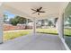 Covered back porch offers a cool space, features a ceiling fan and a view of the backyard at 28 Water Track Dr, Ocala, FL 34472