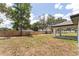 Large backyard featuring a wooden fence, open patio, and green space, perfect for outdoor activities and entertaining at 28 Water Track Dr, Ocala, FL 34472