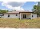 Wide view of a spacious backyard with a well-manicured lawn, leading to a covered back porch at 28 Water Track Dr, Ocala, FL 34472