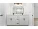 The bathroom has double vanity sinks, white cabinets, black hardware and a large mirror at 28 Water Track Dr, Ocala, FL 34472