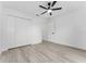 Well-lit bedroom with wood-look floors, fan and closet storage at 28 Water Track Dr, Ocala, FL 34472