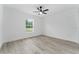 A bright, minimalist bedroom features a ceiling fan and a window with a view of the outdoors at 28 Water Track Dr, Ocala, FL 34472