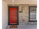 Close-up of the front door with decorative textured stone walls and a colorful welcome mat at 28 Water Track Dr, Ocala, FL 34472