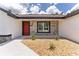 Inviting front porch featuring textured stone walls, a decorative rock garden, and a vibrant red front door at 28 Water Track Dr, Ocala, FL 34472
