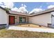 Inviting front porch featuring textured stone walls, a decorative rock garden, and a vibrant red front door at 28 Water Track Dr, Ocala, FL 34472
