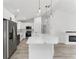Open-concept kitchen with white cabinets, stainless steel appliances, and island at 28 Water Track Dr, Ocala, FL 34472