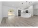 Bright open-concept living space and kitchen with white cabinets, stainless steel appliances, and a sliding glass door to the backyard at 28 Water Track Dr, Ocala, FL 34472