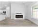 Living area showcasing an electric fireplace, a view into the kitchen, and a window with natural light at 28 Water Track Dr, Ocala, FL 34472