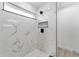 Walk-in shower featuring marble-like tiles and modern black shower head and storage at 28 Water Track Dr, Ocala, FL 34472