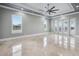 Large bedroom with marble floors, a tray ceiling, modern fan, and bright french doors at 3440 Sw 66Th St, Ocala, FL 34476