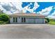 Detached three-car garage with tiled roof and ample parking space, set against a backdrop of clear blue skies at 3440 Sw 66Th St, Ocala, FL 34476