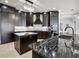 Modern kitchen featuring dark wood cabinets, stainless steel appliances, marble countertops, and a stylish chandelier at 3440 Sw 66Th St, Ocala, FL 34476