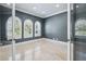 Office space featuring arched windows with shutters, marble floors, neutral paint, and glass doors at 3440 Sw 66Th St, Ocala, FL 34476