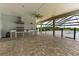Outdoor kitchen and patio area with stainless steel grill, sink, and a screened pool at 3440 Sw 66Th St, Ocala, FL 34476