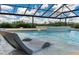 Inviting pool with lounge chairs in the water, a waterfall feature, and a screened enclosure at 3440 Sw 66Th St, Ocala, FL 34476