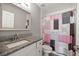 Bathroom features a vanity, shower, toilet, a framed mirror, and a pink, black, white shower curtain at 3645 Sw 151St Ct, Ocala, FL 34481