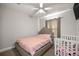 Charming bedroom with pink bedding, a crib, ceiling fan, and soft, natural light filtering in at 3645 Sw 151St Ct, Ocala, FL 34481
