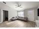 Modern living room with hardwood floors, stylish grey couch and a ceiling fan at 3645 Sw 151St Ct, Ocala, FL 34481