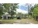 A spacious backyard featuring a grey storage shed and a wooden playset, perfect for outdoor fun and storage at 37 Oak Loop, Ocala, FL 34472