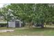Spacious backyard featuring a storage shed and a charming tree swing for relaxation and outdoor enjoyment at 37 Oak Loop, Ocala, FL 34472