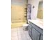 Bathroom with blue vanity and yellow tiled shower and tub at 37 Oak Loop, Ocala, FL 34472