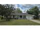 Charming single-story home featuring a cozy front porch, attached garage, and mature landscaping at 37 Oak Loop, Ocala, FL 34472