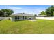 An expansive grassy backyard features a concrete patio, enclosed by a white fence providing privacy at 4325 Se 60Th St, Ocala, FL 34480