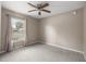 Bedroom with neutral carpet, a ceiling fan, and a window allowing natural light at 4325 Se 60Th St, Ocala, FL 34480