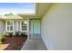 Close-up of a home's welcoming front door with gray shutters and tidy landscaping at 4325 Se 60Th St, Ocala, FL 34480